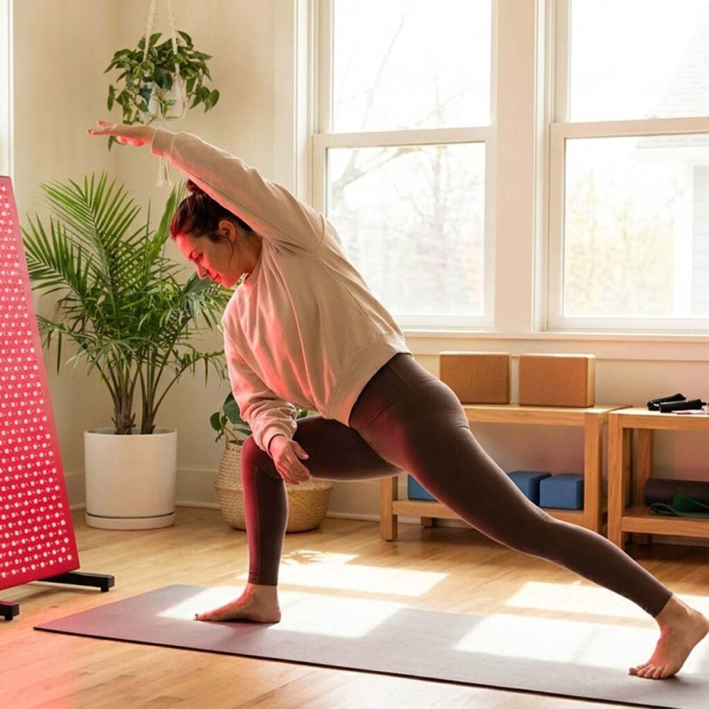 Red Light Therapy Benefits - Woman Stretching In Front Of Red Light | The List Of